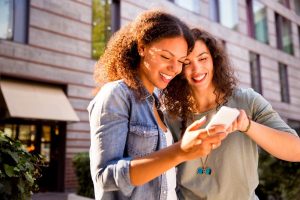 Two women looking at a phone screen. 
