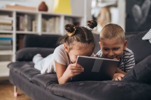 Two children playing on a tablet together. 