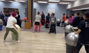 Adults engaged in cardio drumming activity indoors