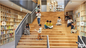An image of children browsing books on the stairs inside the Nakanoshima Childrens Book Forest Library.