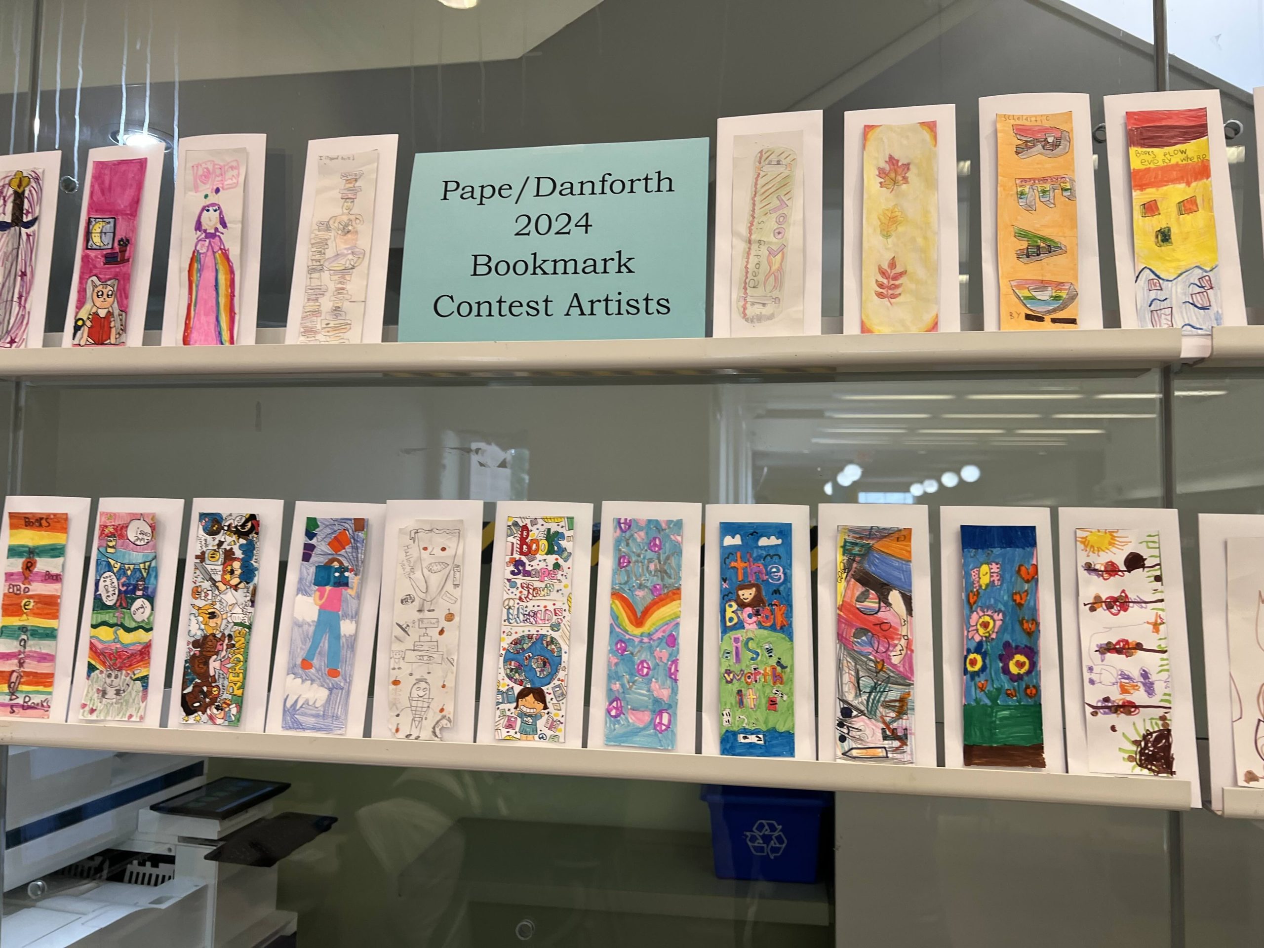 A wall display of bookmarks designed by kids.
