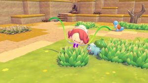 Screenshot from Pokemon Pokopia. Ditto is transformed into their human trainer. Their arms are vines and they have just created a bush on the ground. Bulbasaur is smiling next to them.