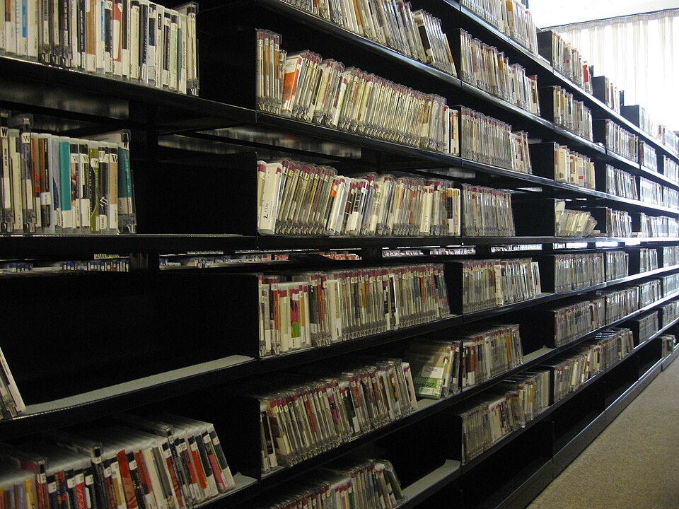 CD's shelved in the library stacks with the spine of the CD faced out and labeled with library organization information