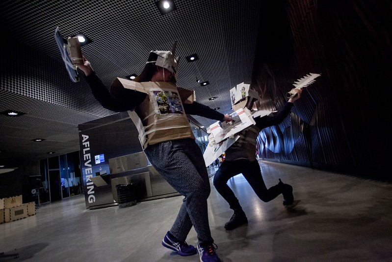 Two people dressed in cardboard knight's armor have a mock battle at the DOKK1 library in Aarhus.
