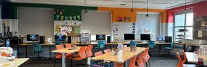 Tables, chairs, and computers in front of a window