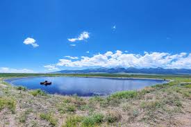 Pond and grass under a blue sky with some white clouds