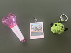 Three keychains on a green background.