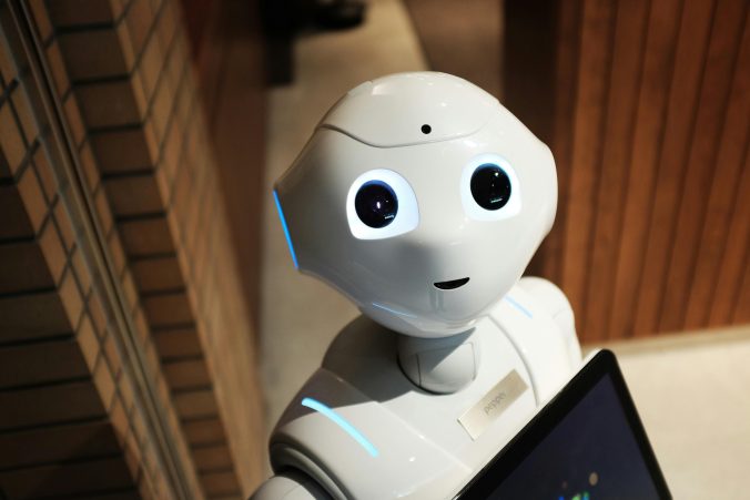 White humanoid robot staring up at camera.