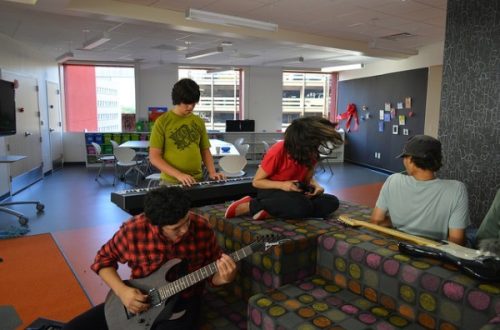 San Antonio Public Library - teens playing guitars in a teen library space.