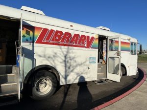 Image of bookmobile from Salem, OR (my hometown). The bookmobile is a white bus with "Library" and a rainbow painted on the outside