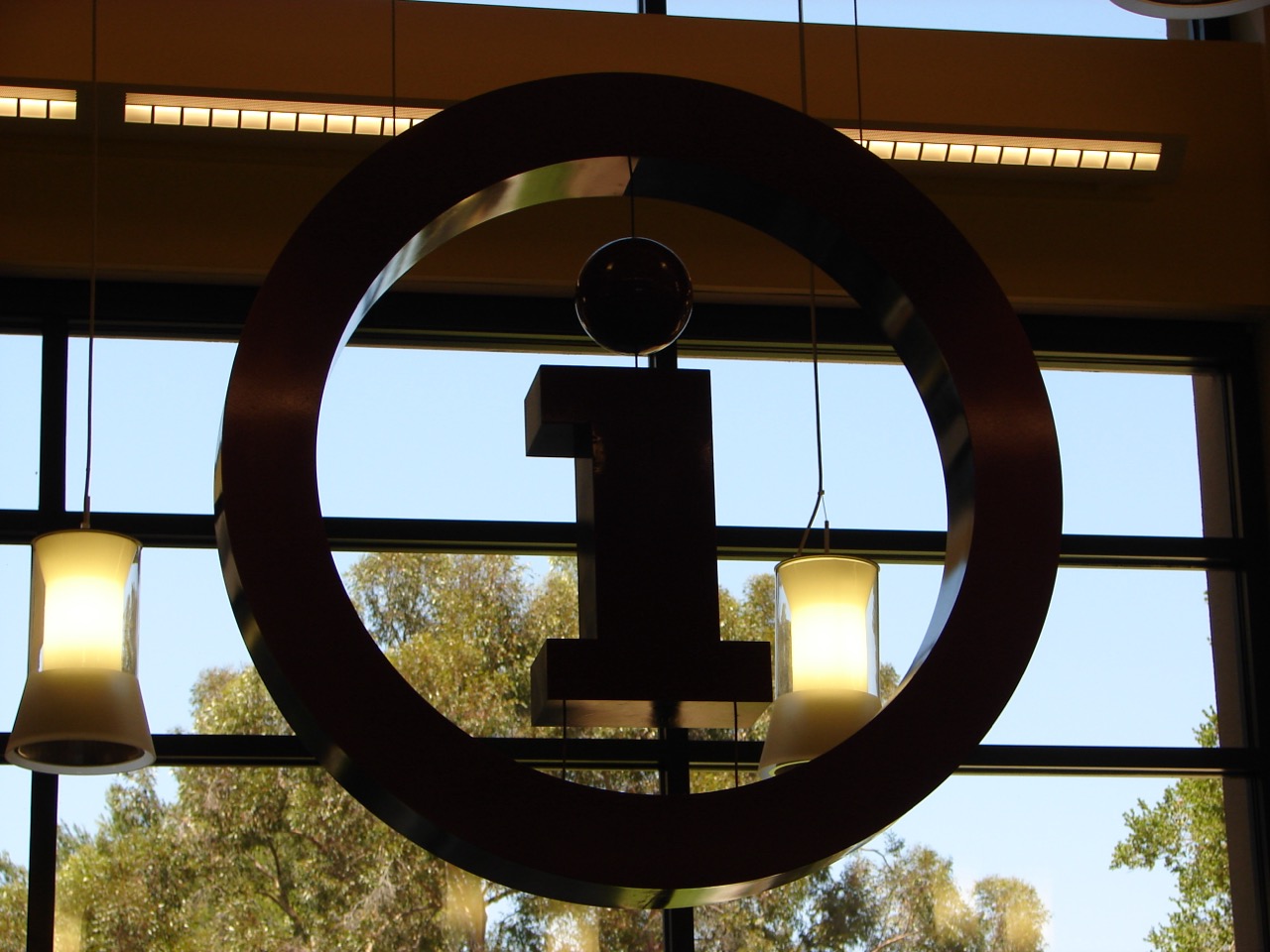 Hanging sign featuring a Lowercase i within a circle.