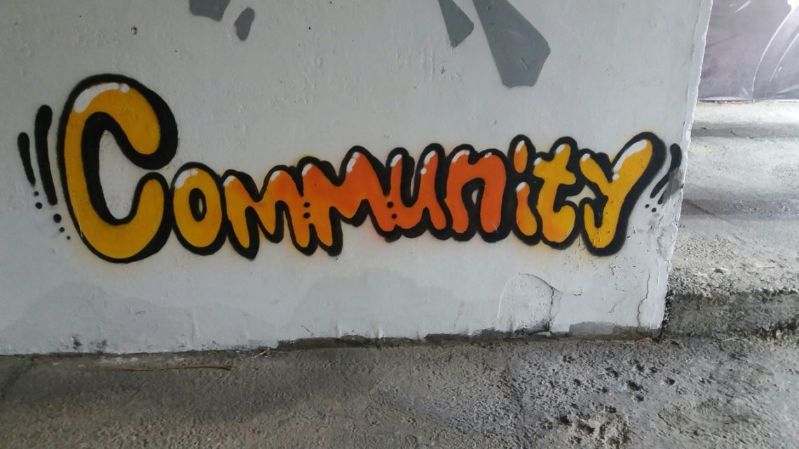 The word community on a white wall as graffiti