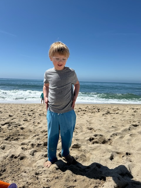 Boy on beach looking down